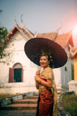 Téléchargez les photos : Femme asiatique tenant parapluie en bambou debout devant de vieux temle dans ayutthaya site du patrimoine mondial de l'Unesco thailand - en image libre de droit