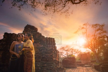 Téléchargez les photos : Deux asiatique femme portant thai tradition vêtements debout dans vieux temple de ayutthaya patrimoine mondial site de l'Unesco central de thailand - en image libre de droit