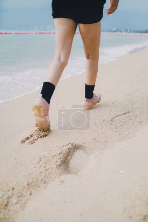 Téléchargez les photos : Étape de la femme jambe marche en avant sur la plage de la mer - en image libre de droit