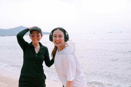 Téléchargez les photos : Couples de femme asiatique portant sport casual costume bonheur sur mer plage - en image libre de droit