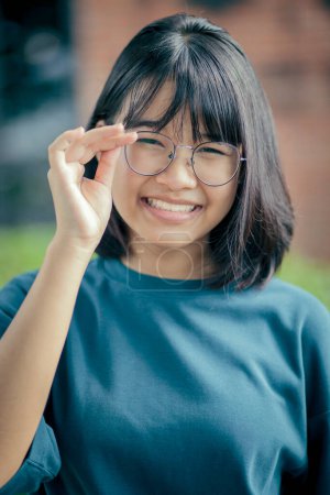 Téléchargez les photos : Portrait d'adolescent asiatiqueportant des vêtements décontractés dents souriant avec bonheur visage - en image libre de droit