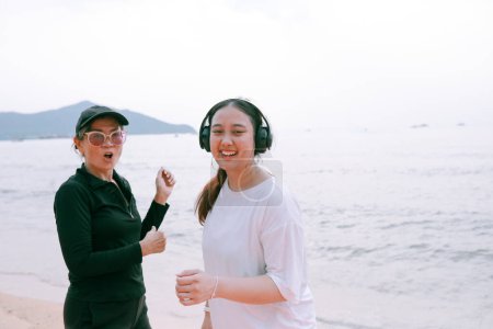 Téléchargez les photos : Deux asiatique femme porter sport casual porter bonheur sur mer plage - en image libre de droit