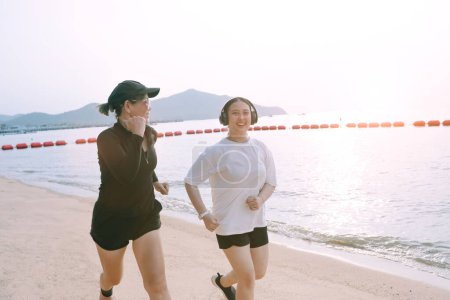 Téléchargez les photos : Deux asiatique femme courir sur mer plage avec bonheur - en image libre de droit