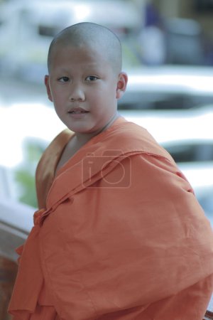 Téléchargez les photos : Portrait de novice bouddhiste portant des vêtements de moine thaï debout en plein air - en image libre de droit