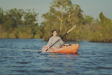 Téléchargez les photos : Asiatique jeune femme kayak dans l'eau douce lagune à rayong province est de thailand - en image libre de droit