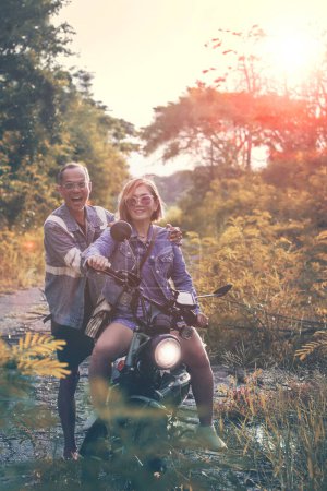 Téléchargez les photos : Couples asiatiques équitation petite enduro moto bonheur sur jungle piste - en image libre de droit