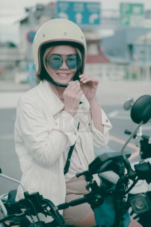 Téléchargez les photos : Femme portant un casque de sécurité debout sur la route de la ville sourire avec bonheur visage - en image libre de droit
