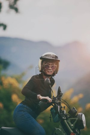 Téléchargez les photos : Femme portant un casque de sécurité équitation petite moto enduro sur un beau fond - en image libre de droit
