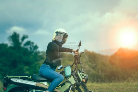 Téléchargez les photos : Femme portant un casque de sécurité équitation petite moto enduro sur un beau fond - en image libre de droit