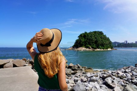 Téléchargez les photos : Fille voyageuse regardant l'île inhabitée d'Urubuquecaba près de la côte de Santos, Baixada Santista, Brésil - en image libre de droit