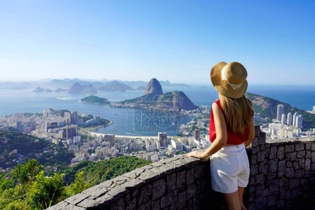 Tourismus in Rio de Janeiro. Rückansicht der Reisenden Mädchen genießen Anblick der berühmten Guanabara-Bucht mit Zuckerhut in Rio de Janeiro, UNESCO-Weltkulturerbe, Brasilien.