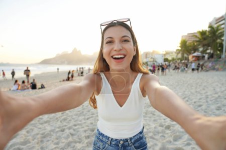 Self portrait of happy cheerful Brazilian girl on Ipanema beach at sunset, Rio de Janeiro, Brazil