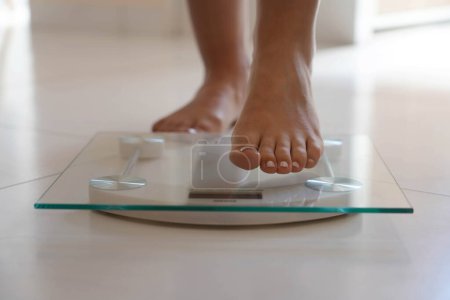 Foto de Primer plano del pie femenino pisando la báscula de peso. Estilo de vida saludable, dieta y concepto deportivo. - Imagen libre de derechos
