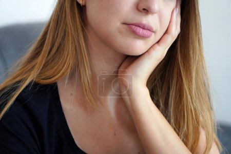 Photo for Girl with her face resting on her hand. Toothache. Depression. Mental health. - Royalty Free Image