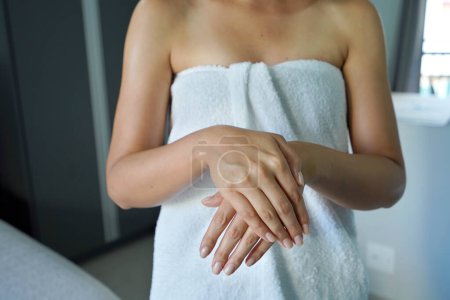 Mädchen zeigt ihre befeuchteten Hände mit Nägeln. Unbekannte feuchten ihre Hände mit feuchtigkeitsspendender Creme. Körperlotion, Feuchtigkeitscreme, Kosmetikkonzept.