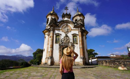 Vacaciones en Ouro Preto, Brasil. Vista trasera de la chica viajera en Ouro Preto visitando la iglesia de San Francisco de Asís en el estado de Minas Gerais, Brasil. Patrimonio mundial de la UNESCO.
