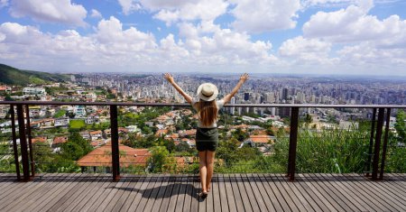 Tourismus in Belo Horizonte, Brasilien. Panorama-Banner-Ansicht einer Touristin mit erhobenen Armen vom schönen Aussichtspunkt in Belo Horizonte, Minas Gerais, Brasilien.