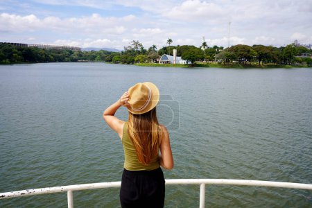 Photo for Traveling in Brazil. Panoramic view of tourist woman looking the Pampulha Modern Ensemble in Belo Horizonte, UNESCO World Heritage Site, Minas Gerais, Brazil. - Royalty Free Image