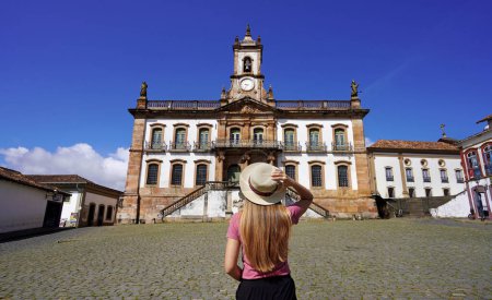 Tourismus in Ouro Preto, Brasilien. Junge Touristin besucht Tiradentes Square, berühmtes Wahrzeichen der Stadt Ouro Preto, Unesco-Weltkulturerbe im Bundesstaat Minas Gerais, Brasilien.