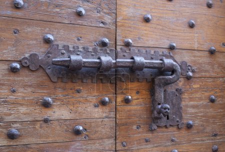Antique door latch in the Italian countryside. High quality photo.