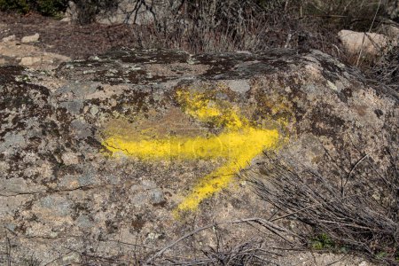 Foto de Old stone wall with yellow arrow Camino de Santiago, dirt road, - Imagen libre de derechos