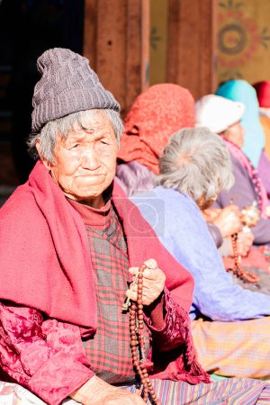 Foto de Thimphu, Bután - 04 de diciembre de 2018: Vieja butanesa rezando en él Thimphu Chorten. Foto de alta calidad - Imagen libre de derechos