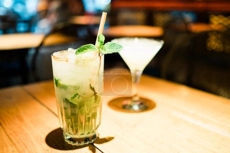 Téléchargez les photos : Cocktail alcoolisé Mojito à la menthe, tranches de lime et glace sur un bar. Photo de haute qualité - en image libre de droit
