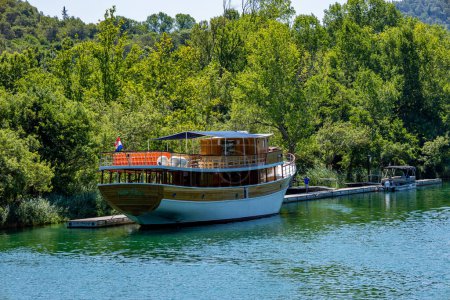 Photo for Beautiful landscape in the Krka National Park in Croatia. Natural Waterfalls. Natural wonders. A tourism boat sailing on the water near Krka National Park, Croatia - Royalty Free Image