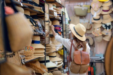 Foto de Mujer asiática de viajes y compras en la tienda de sombreros de paja en el mercado de platino en la ciudad de Bangkok, Tailandia - Imagen libre de derechos
