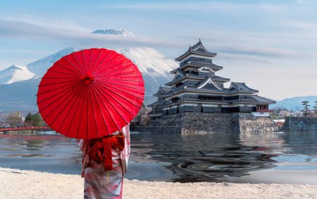 japanische Burg in Tokio mit Kirschblüte, Reiseleiterin in traditioneller Kimono-Kleidung, Fuji-Berg blauer Himmel und Spiegelbild der Burg im Fluss, Tokio Stadt, Japan