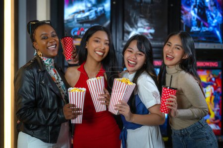 Foto de Feliz grupo de amigos de mujer asiática relajarse e ir a Cimema en el cine juntos y comprar entradas y palomitas de maíz en el servicio de contador de ventas - Imagen libre de derechos