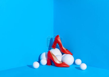 Foto de Una toma de estudio de zapatos clásicos de mujer rojos colocados en la esquina del espacio de color azul en esferas blancas. Blog de moda o concepto de revista. Copiar espacio. - Imagen libre de derechos