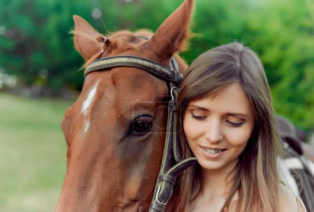 Téléchargez les photos : Une femme et un cheval sont représentés en gros plan dans un cadre rural. Les sports équestres favorisent la relaxation et la réduction du stress. L'hippothérapie, les animaux qui réduisent le stress, et une carte cadeau émotionnelle - en image libre de droit