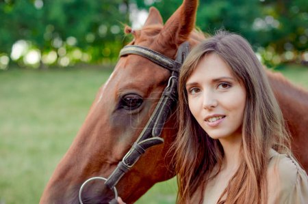 Téléchargez les photos : Portrait rapproché d'une femme et d'un cheval dans un paysage rural. L'équestre favorise le bien-être et le soulagement du stress. L'hippothérapie, les animaux aident au stress, un certificat cadeau pour les émotions - en image libre de droit
