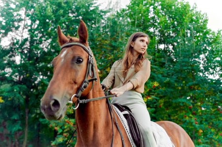 Téléchargez les photos : Monter une monture. Femme à cheval à la campagne. L'équitation favorise le bien-être, la relaxation. S'engager dans la thérapie de cheval, profiter des week-ends de la nature, et favoriser la communication animale pour l'équilibre émotionnel. - en image libre de droit