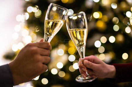 Crop close up of man and woman hold glasses with champagne clink greet congratulate with New Year. 