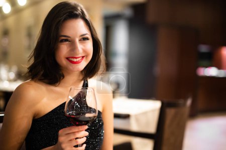 Téléchargez les photos : Belle femme tenant un verre de vin rouge - en image libre de droit
