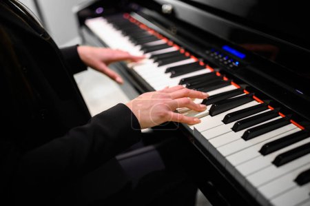 Foto de Primer plano de un músico tocando un teclado de piano - Imagen libre de derechos