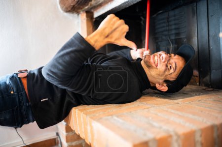 Téléchargez les photos : Young chimney sweep at work showing thumbs up - en image libre de droit