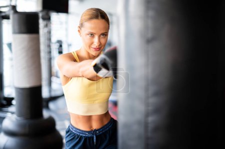 Foto de Beautiful young woman lifting dumbbells in a gym - Imagen libre de derechos