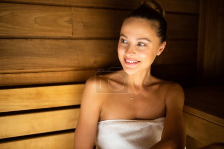 Téléchargez les photos : Femme se relaxant dans un sauna dans un centre de bien-être - en image libre de droit