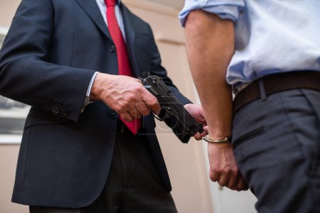 Photo for Agent arresting a businessman in his office - Royalty Free Image