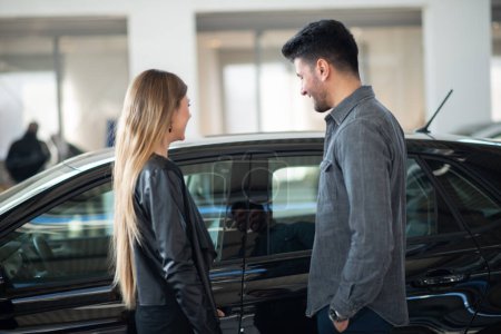 Téléchargez les photos : Couple choisissant leur nouvelle voiture chez un concessionnaire - en image libre de droit