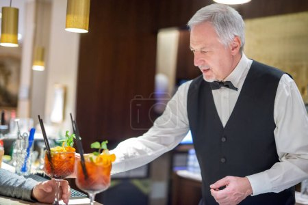 Téléchargez les photos : Barman expert servant deux cocktails - en image libre de droit