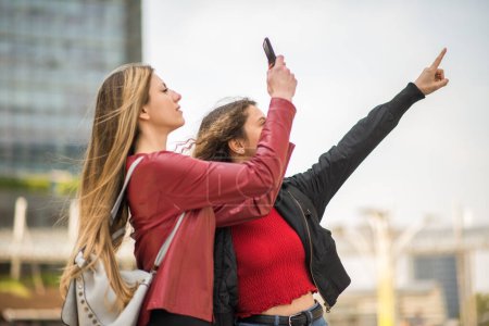 Téléchargez les photos : Amis utilisant leur smartphone pour tirer sur un endroit intéressant - en image libre de droit