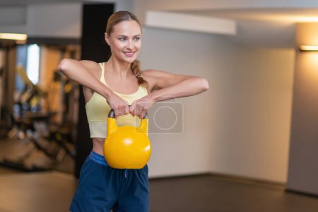 Photo for Woman training with a kettlebell in a gym - Royalty Free Image