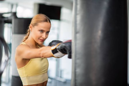 Foto de Entrenamiento de mujer en el saco de boxeo en un gimnasio, concepto de fitness - Imagen libre de derechos