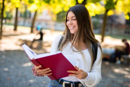Téléchargez les photos : Jeune femme lisant un livre dans un parc - en image libre de droit