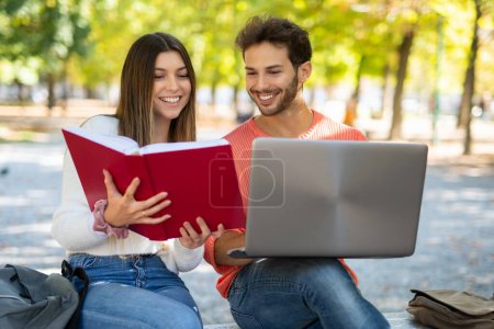 Photo for College students using a laptop computer in a park, young people and technology concept - Royalty Free Image