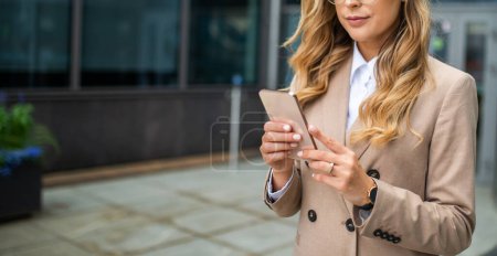 Foto de Detalle de una mujer usando su teléfono inteligente al aire libre. Anónimo, no se muestra cara - Imagen libre de derechos